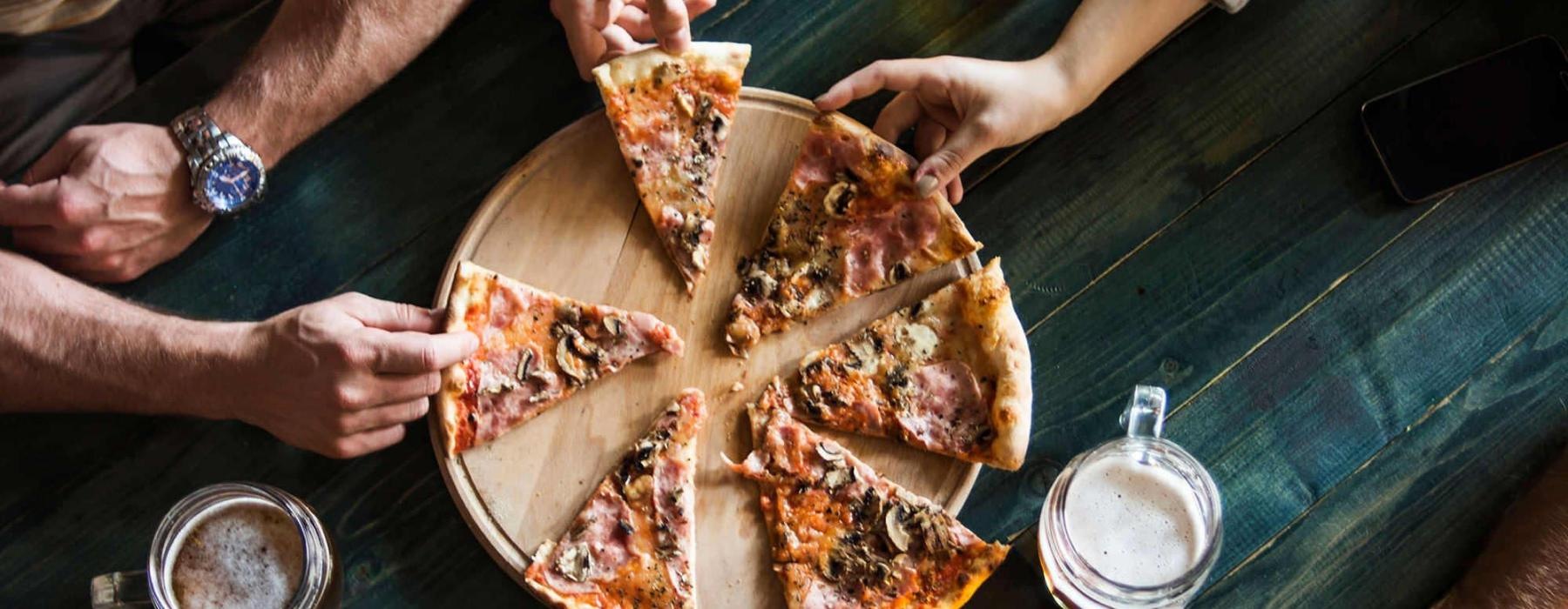 a group of people eating pizza